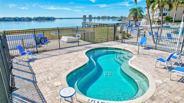 view of pool with a patio and a water view