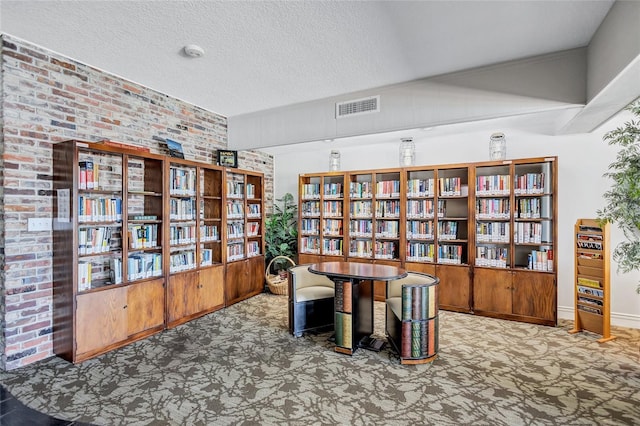 carpeted home office featuring a textured ceiling