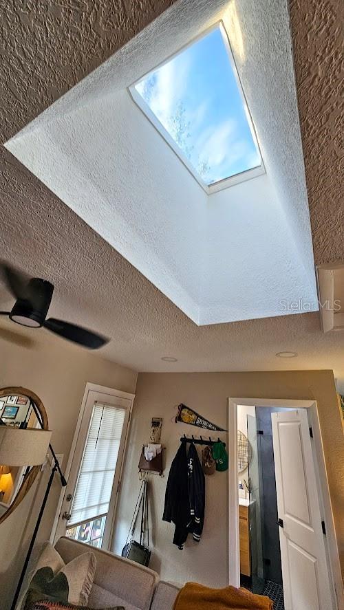 room details with ceiling fan and a textured ceiling