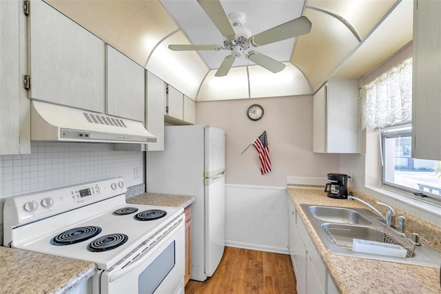 kitchen with light wood-style flooring, under cabinet range hood, white electric range, a sink, and backsplash