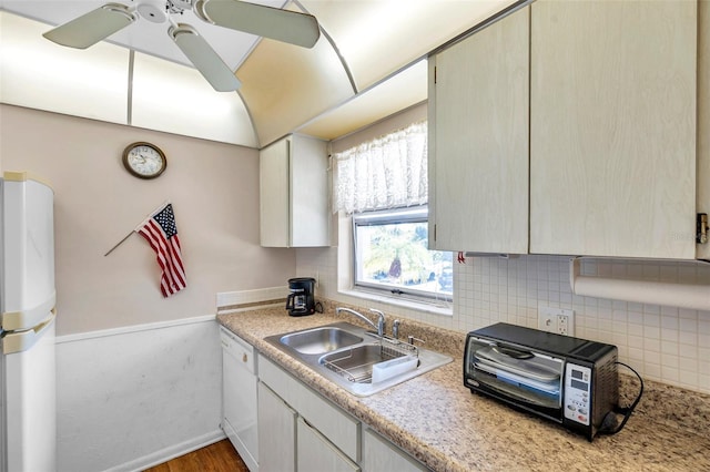 kitchen with white appliances, tasteful backsplash, a ceiling fan, light countertops, and a sink