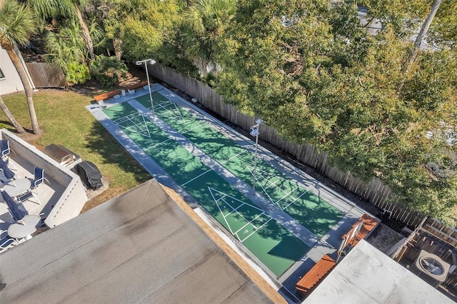 surrounding community with fence, a lawn, and shuffleboard