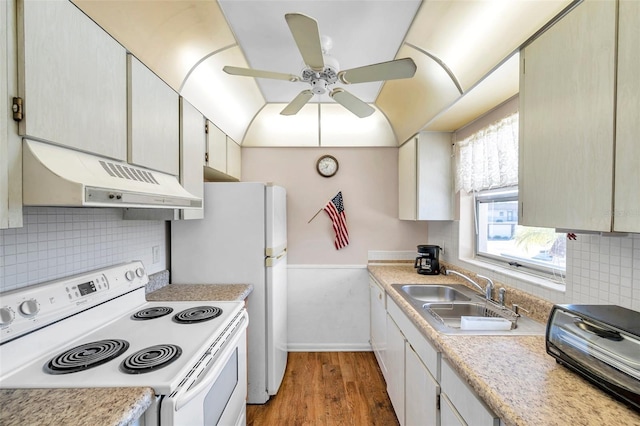 kitchen featuring white electric stove, under cabinet range hood, a sink, light countertops, and light wood finished floors