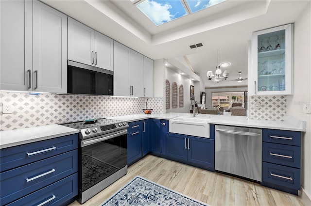 kitchen featuring blue cabinets, white cabinetry, appliances with stainless steel finishes, and sink