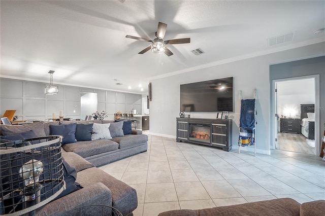 tiled living room featuring ornamental molding and ceiling fan