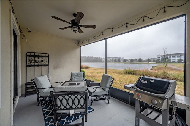 sunroom / solarium with a water view and ceiling fan