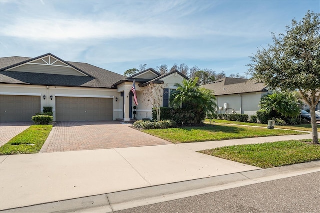 ranch-style home featuring a garage and a front lawn