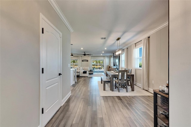 dining space featuring crown molding and light wood-type flooring