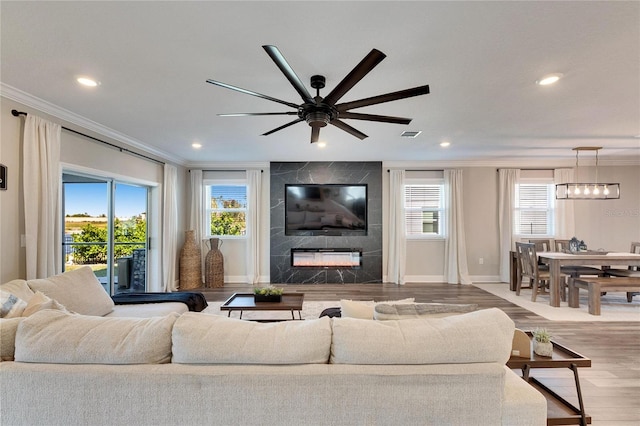 living room featuring ornamental molding, a fireplace, and light wood-type flooring