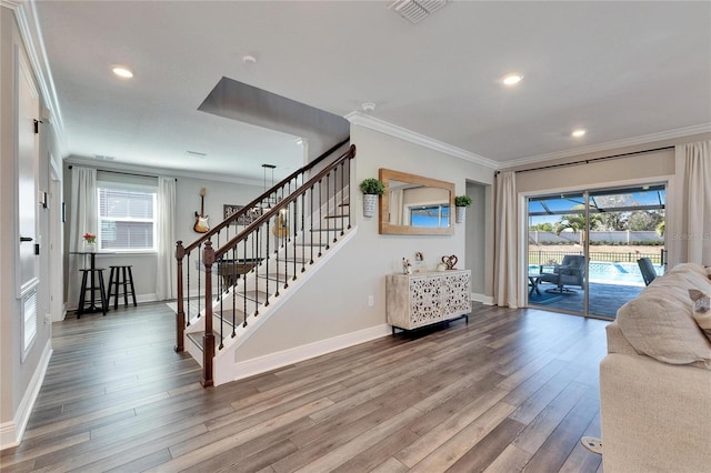 living room with hardwood / wood-style flooring, crown molding, and a wealth of natural light