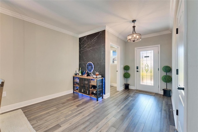 foyer entrance featuring crown molding, hardwood / wood-style floors, and a notable chandelier