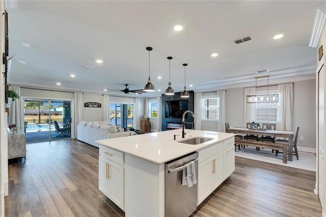 kitchen with a center island with sink, sink, stainless steel dishwasher, and white cabinets