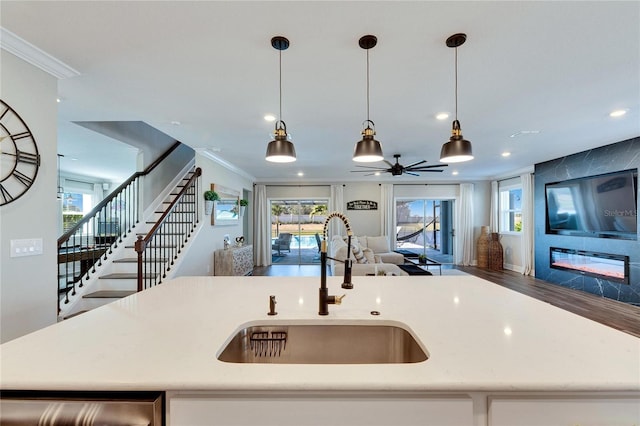 kitchen featuring sink, hanging light fixtures, and an island with sink