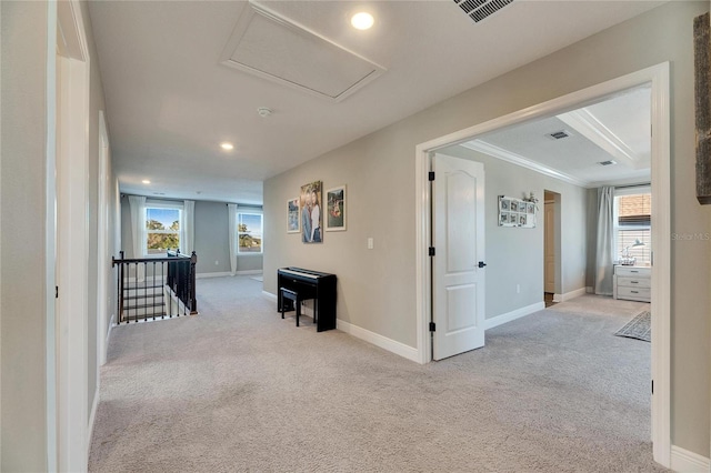 hallway with a healthy amount of sunlight and light colored carpet