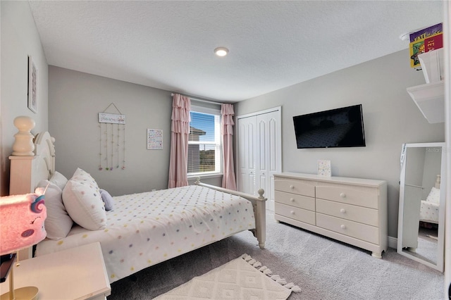 bedroom featuring light colored carpet, a closet, and a textured ceiling