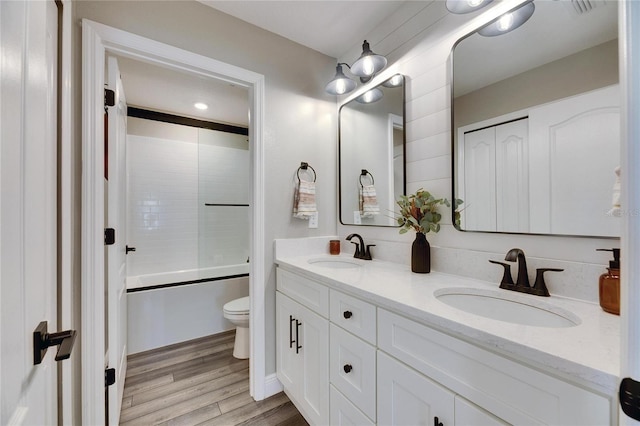 full bathroom with vanity, wood-type flooring, toilet, and washtub / shower combination