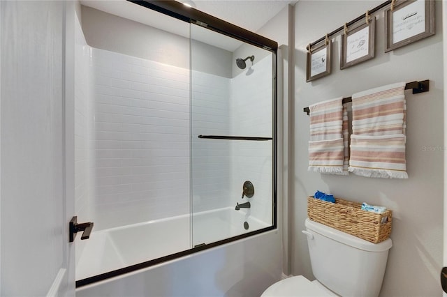 bathroom featuring enclosed tub / shower combo and toilet