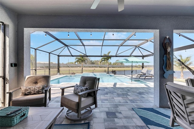 view of patio featuring a fenced in pool, ceiling fan, and glass enclosure