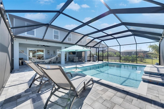 view of pool featuring a lanai, ceiling fan, and a patio area