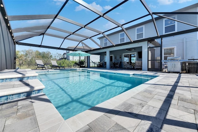 view of swimming pool featuring cooling unit, ceiling fan, a patio, and glass enclosure