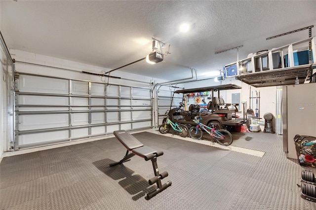 garage with a garage door opener and stainless steel refrigerator