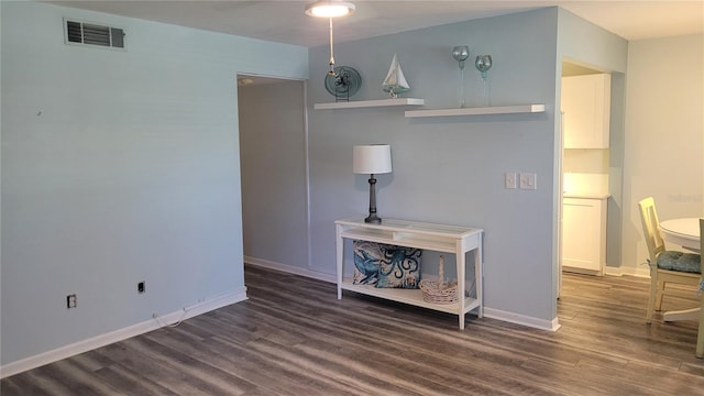 living room featuring wood finished floors, visible vents, and baseboards