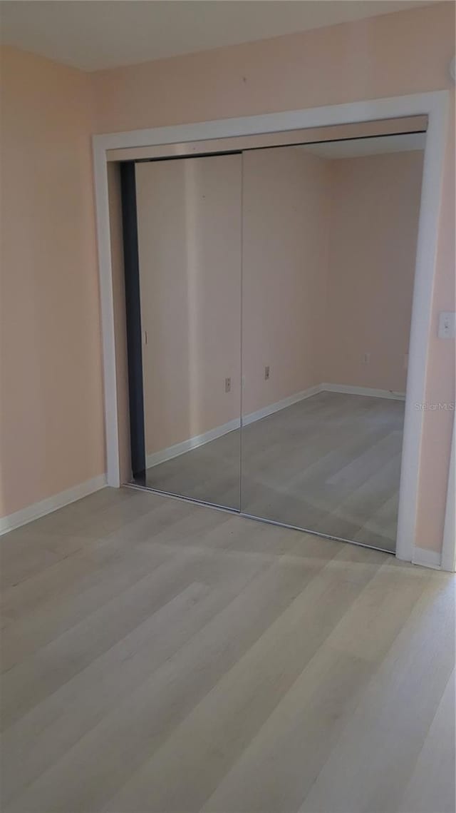 unfurnished bedroom featuring a closet and light hardwood / wood-style flooring