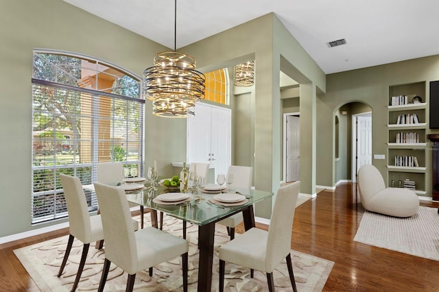 dining room with dark hardwood / wood-style floors and a chandelier