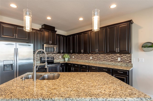 kitchen featuring hanging light fixtures, appliances with stainless steel finishes, and dark brown cabinets