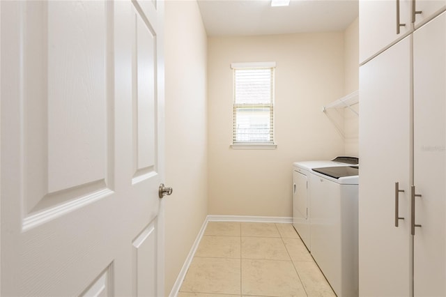 washroom featuring separate washer and dryer, light tile patterned floors, and cabinets