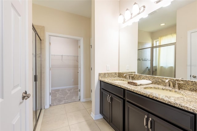 bathroom with walk in shower, vanity, and tile patterned flooring