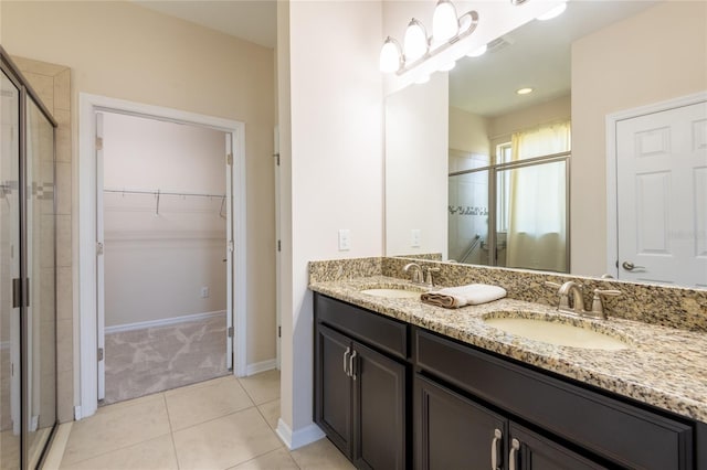 bathroom featuring tile patterned flooring, vanity, and walk in shower