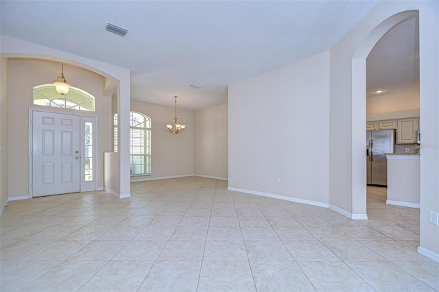 entryway featuring light tile patterned floors and a chandelier