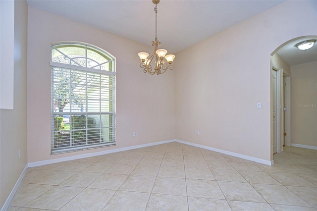 tiled empty room with a chandelier