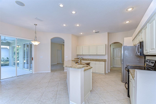 kitchen featuring pendant lighting, appliances with stainless steel finishes, white cabinetry, light stone counters, and light tile patterned flooring