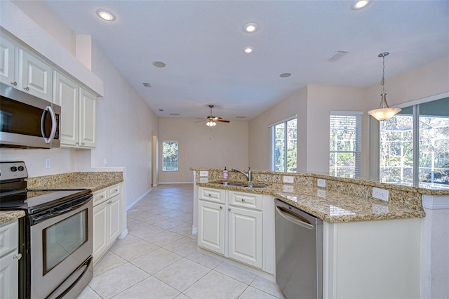 kitchen featuring pendant lighting, stainless steel appliances, sink, and white cabinets