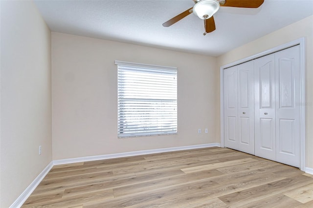 unfurnished bedroom with ceiling fan, light hardwood / wood-style floors, and a closet