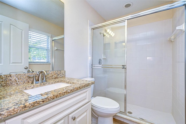 bathroom featuring an enclosed shower, vanity, and toilet