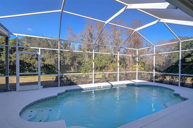 view of swimming pool with glass enclosure and a patio area