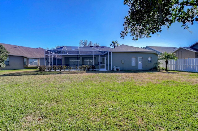 rear view of house featuring a yard and a lanai