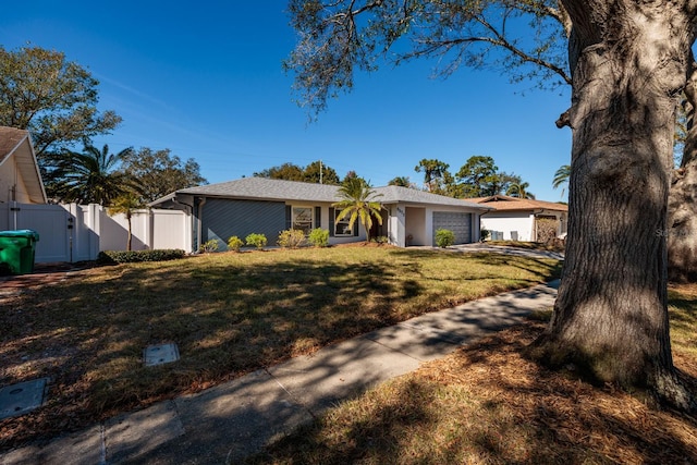 ranch-style home featuring a garage and a front yard