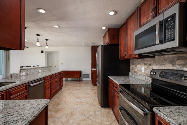 kitchen featuring appliances with stainless steel finishes, light stone counters, tasteful backsplash, a textured ceiling, and light tile patterned flooring