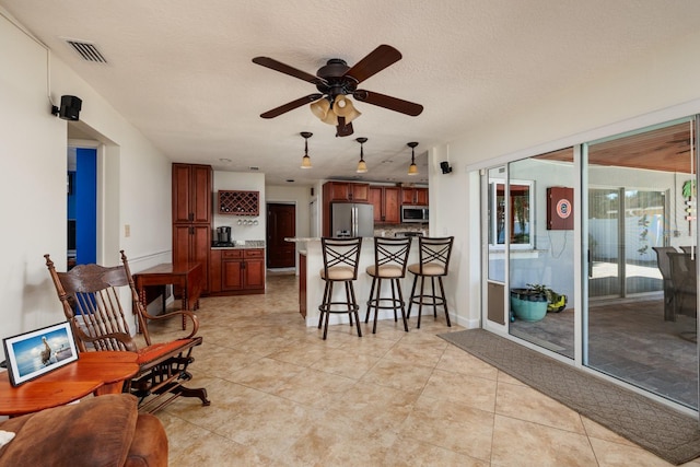 interior space with a textured ceiling and ceiling fan