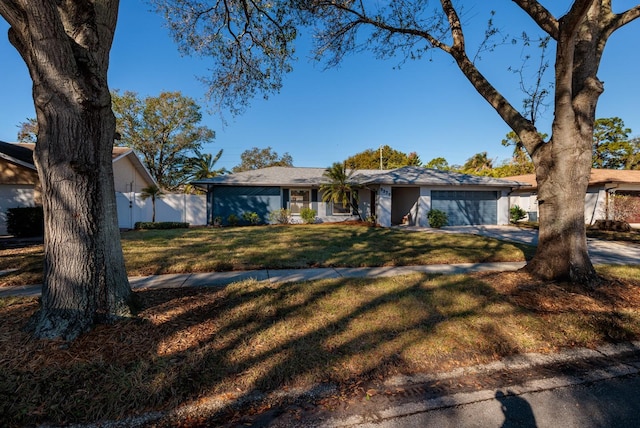 ranch-style house featuring a garage and a front yard