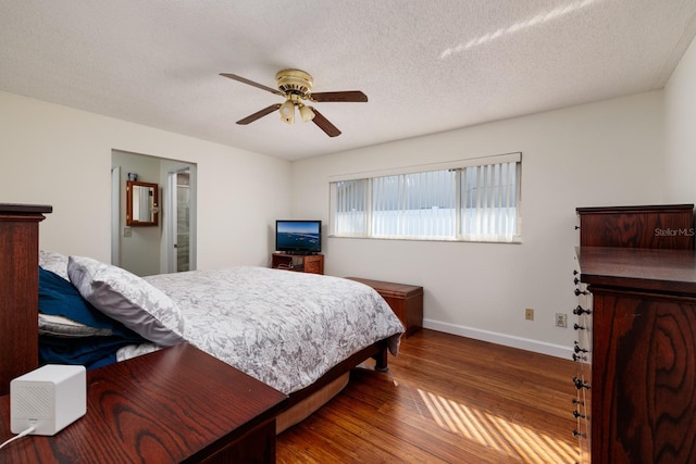 bedroom featuring ceiling fan, a textured ceiling, and dark hardwood / wood-style flooring