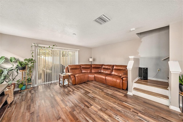 living room with wood-type flooring and a textured ceiling