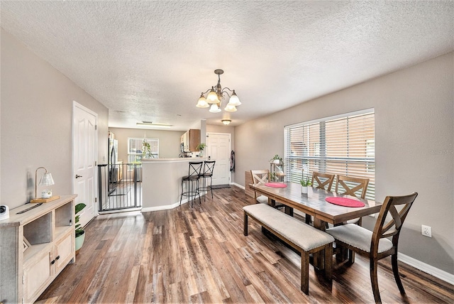 dining space featuring an inviting chandelier, hardwood / wood-style floors, and a wealth of natural light