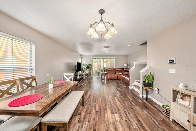 dining room featuring a notable chandelier, dark hardwood / wood-style floors, and a textured ceiling