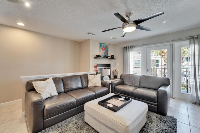 tiled living room featuring ceiling fan and a textured ceiling