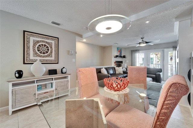 dining area with ceiling fan, a textured ceiling, and light tile patterned flooring